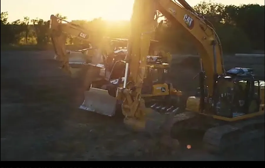 A fleet of retrofitted Caterpillar machines on a Texas job site at sunrise.